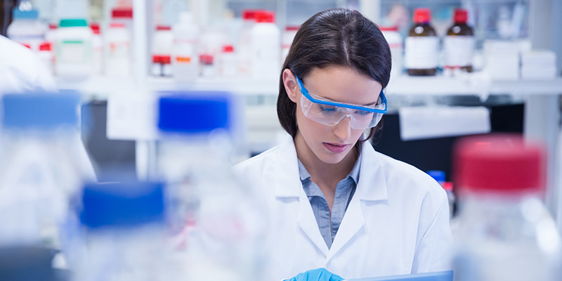 Woman in sceintific environment focussing on test out of shot