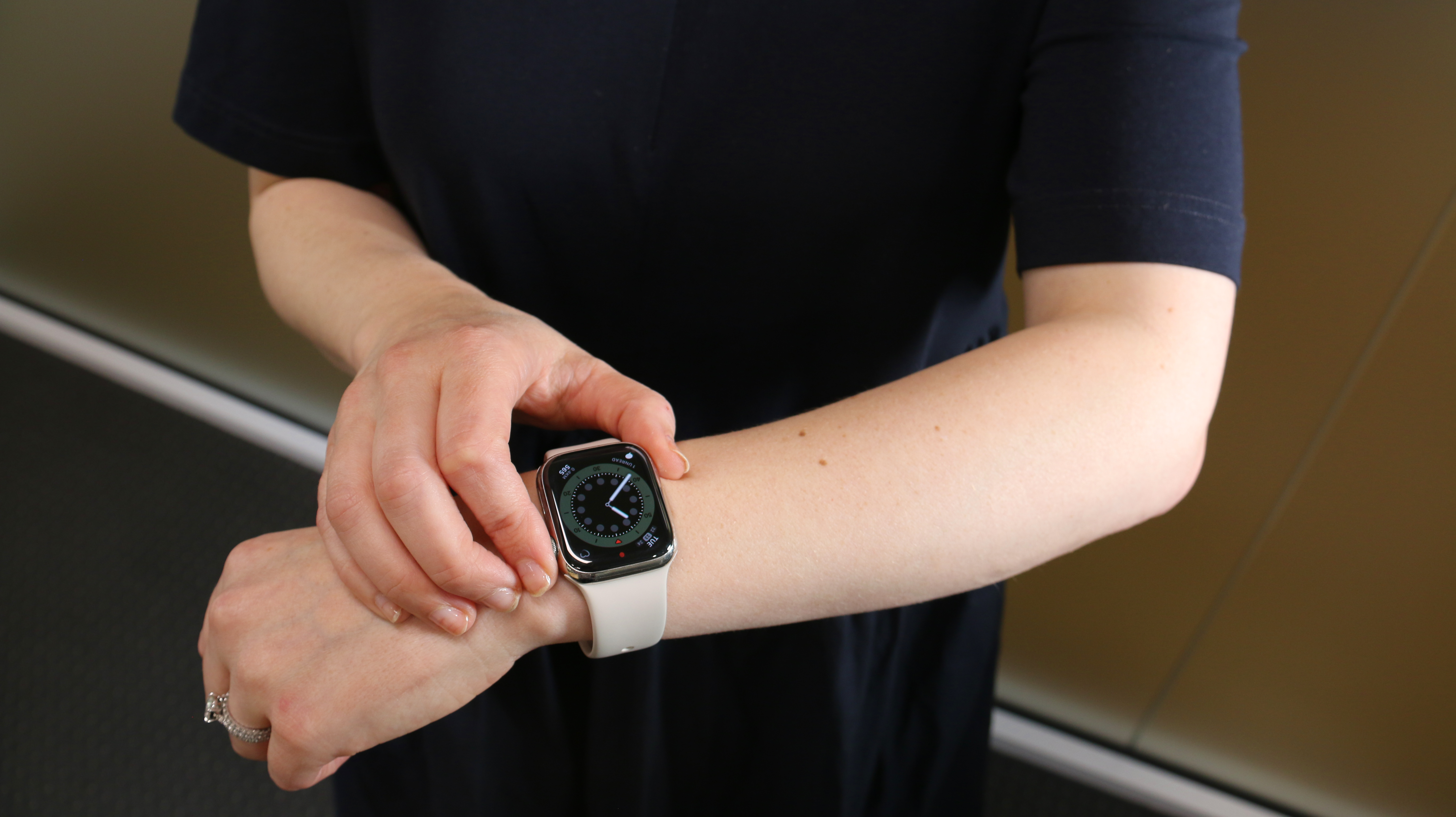 A woman is playing with a smart watch on her arm