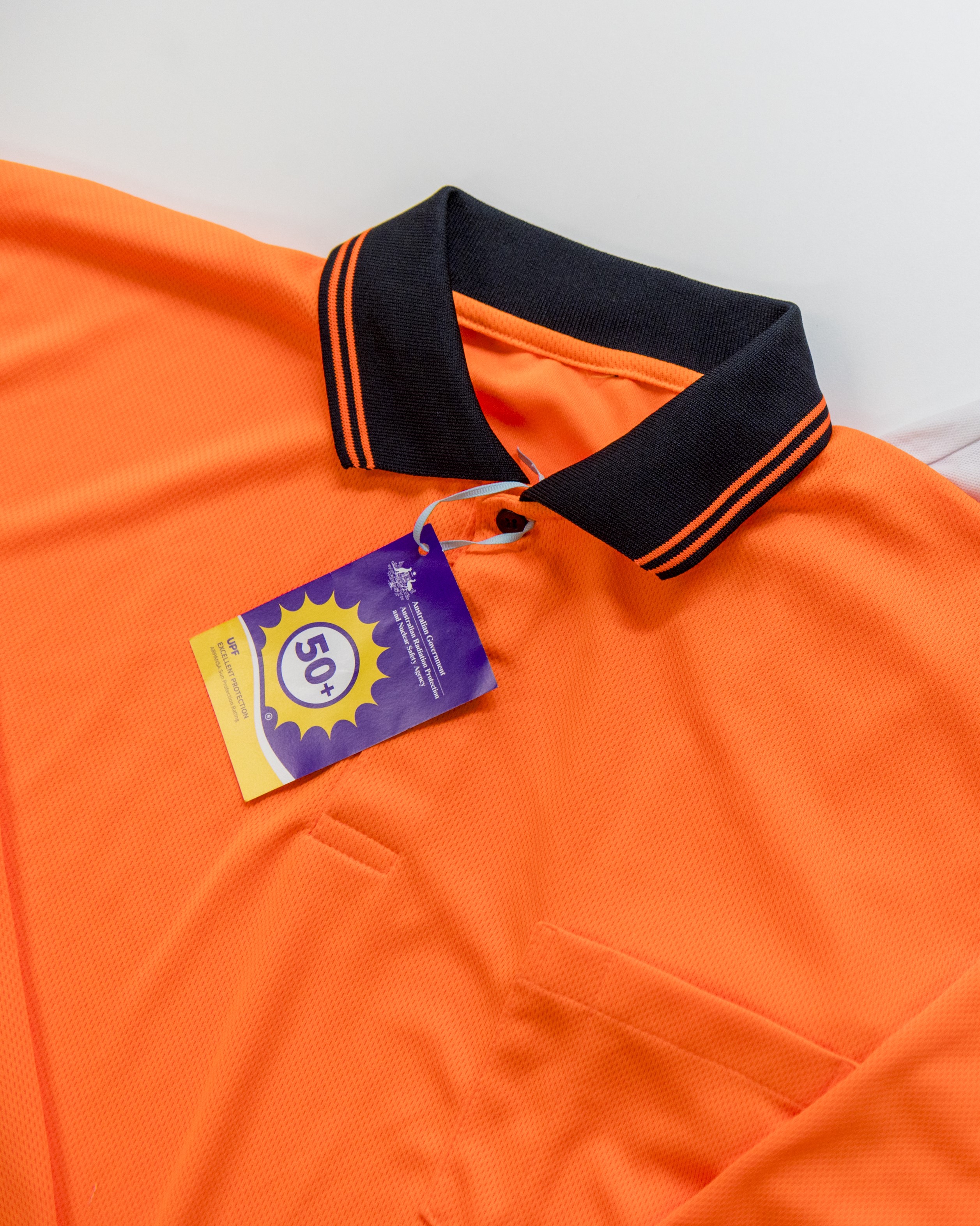 An orange shirt has a sun protection label on it 