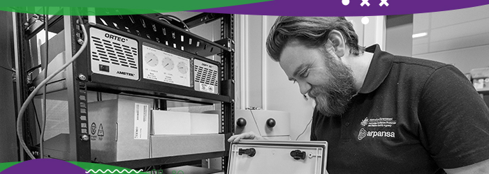 Man smiling and looking intently at electrical equipment