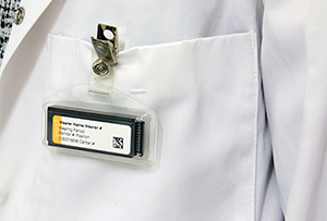 OSL monitor clipped to the pocket of a lab coat.