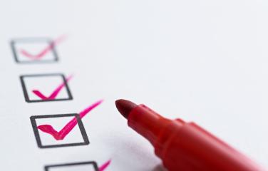 Close up of tip of pen ticking check boxes