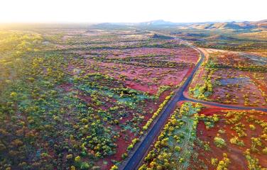 An image of the Pilbara region in WA with a road in the middle. It is sparse road country with a remote road