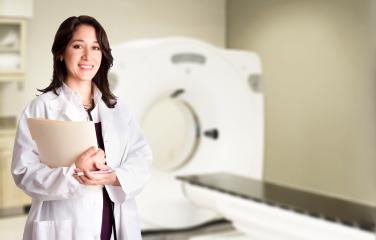 Female doctor standng in front of medical scanner
