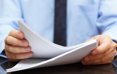 Close up man’s hands on a desk holding pieces of paper