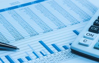 Accounting and financial papers, analysis charts, pen and calculator.
