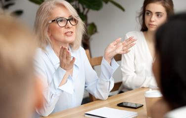 Image of woman talking to people around a table