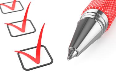 Red pen on a checklist with red ticks in all of the boxes.