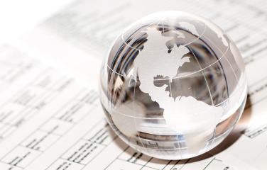 Glass globe paperweight on top of paperwork.