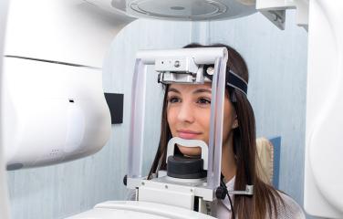 Close-up head shot of girl getting a 3D dental X-ray.
