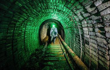 Man in protective suit inside abandoned uranium mine.
