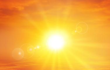 A panoramic shot of a warm and radiant setting sun in the sky.