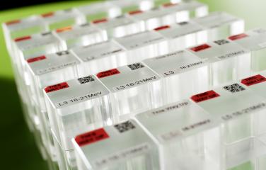 Five rows of five transparent cube shaped prisms with red and yellow labels on a green background