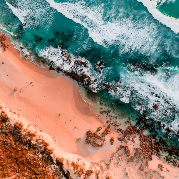 Red Rocky Cliff Coastline Against Turquoise Ocean Waves Coral Reef Western Australia