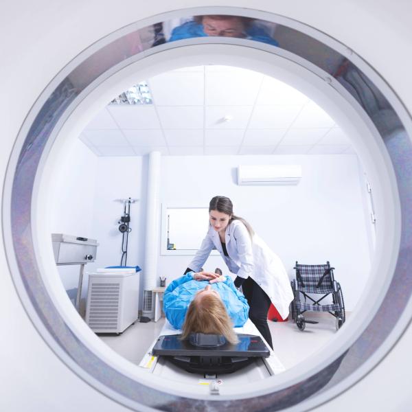 Cancer treatment in a modern medical private clinic or hospital with a linear accelerator. Professional doctors team working while the woman is undergoing radiation therapy for cancer