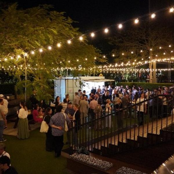 A group of people are gathered outside in Cairns and mingling with each other