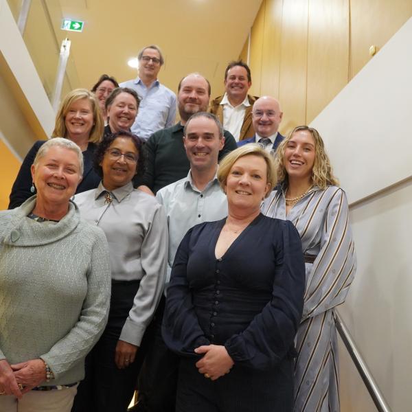 A group photo of people on a stairwell 