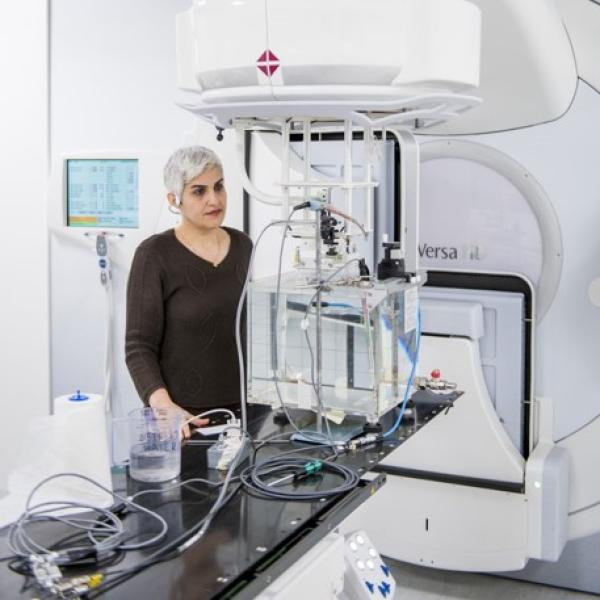 A female scientist is working with a primary standard device for ionising radiation dose