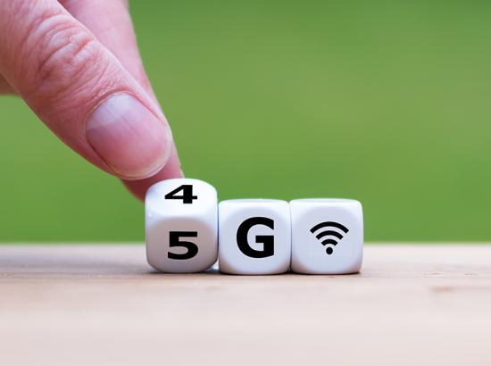 human fingers turning a 4G cube into a 5G cube - the cube has writing '4G' and the writing is being moved to say '5G'