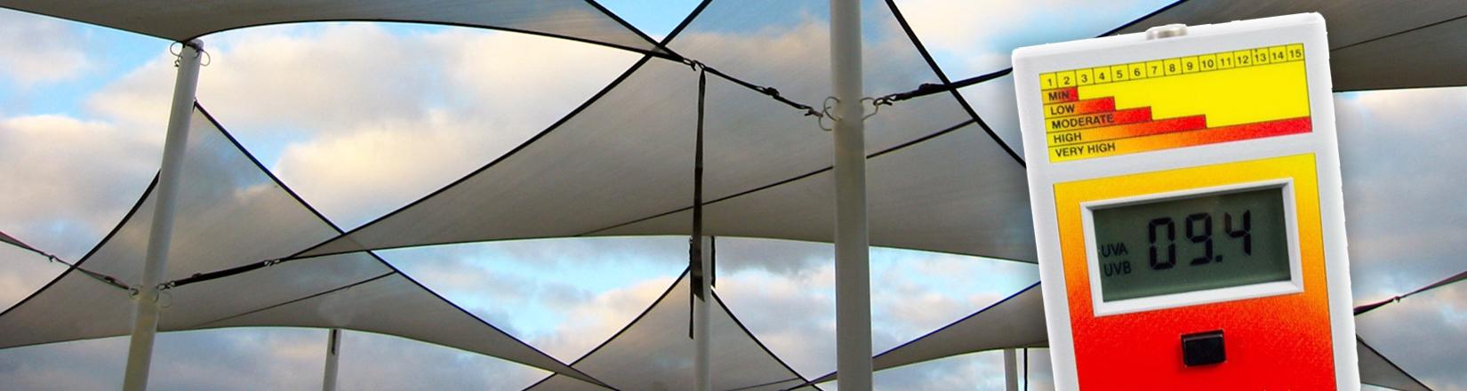 UV index meter held in front of shade sail structure UV index meter held in front of shade sail structure