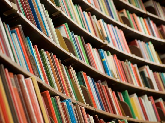 Library bookshelves with varying colours and sizes of books.