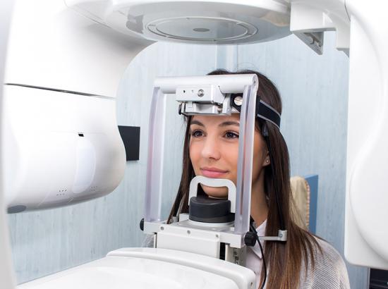 Close-up head shot of girl getting a 3D dental X-ray.