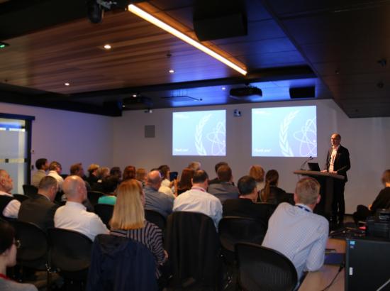 Hilaire Mansoux speaking to a crowded room